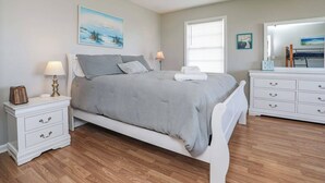 A bedroom with a bed, bedside tables, a dresser, and a window. - Sneads Ferry 4BR Waterfront Home Near Camp Lejeune (Sneads Ferry)