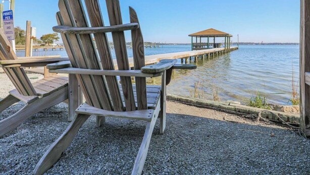 A wooden Adirondack chair by a waterfront, a gazebo, and a private pier sign. - Sneads Ferry 4BR Waterfront Home Near Camp Lejeune (Sneads Ferry)
