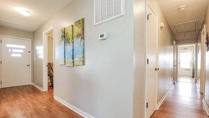 A hallway with wooden flooring, white walls, and a door leading to another room. - Sneads Ferry 4BR Waterfront Home Near Camp Lejeune (Sneads Ferry)