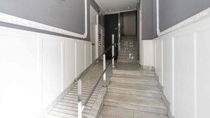 A staircase with a metal handrail and white walls. - San Martin II | The Rentals Collection (San Sebastián)