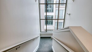 A stairwell with a view of a building through a large window.