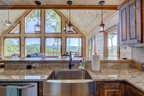 Enjoy expansive views of the surrounding landscape from the large windows in this kitchen.