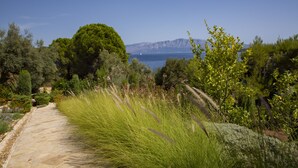 A stone pathway leading to a scenic overlook with a view of the sea and mountains. - Private waterfront villa with pool and two private beaches (geni)