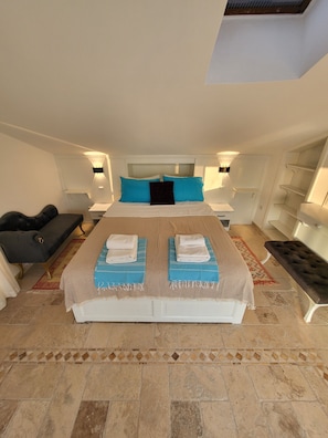 Relax in this serene bedroom with a large bed, two nightstands, and a cozy atmosphere.