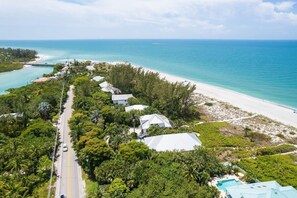 An aerial view of a coastal property with a road, beach, and ocean. - A Saba Wind South- Oceanfront Estate with Pool on Captiva Island! (Captiva)