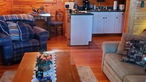A cozy cabin interior with a dining area, kitchen, and seating space.