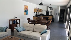 Un salon moderne comprenant un canapé, une table basse et un coin repas avec des chaises et une table.