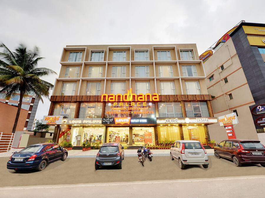 A multi-story hotel with a prominent 'nanthana' sign, featuring storefronts for 'Louis Vuitton' and 'Levi's'.
