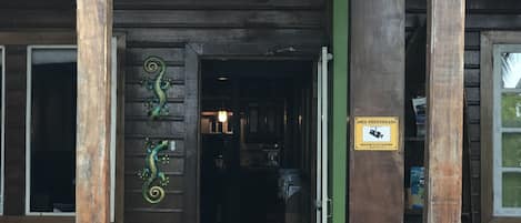 Un cartell de fusta amb la inscripció "Welcome to LULAS" penjat sobre una porta, flanquejat per dos llangostes metàl·liques decoratives.