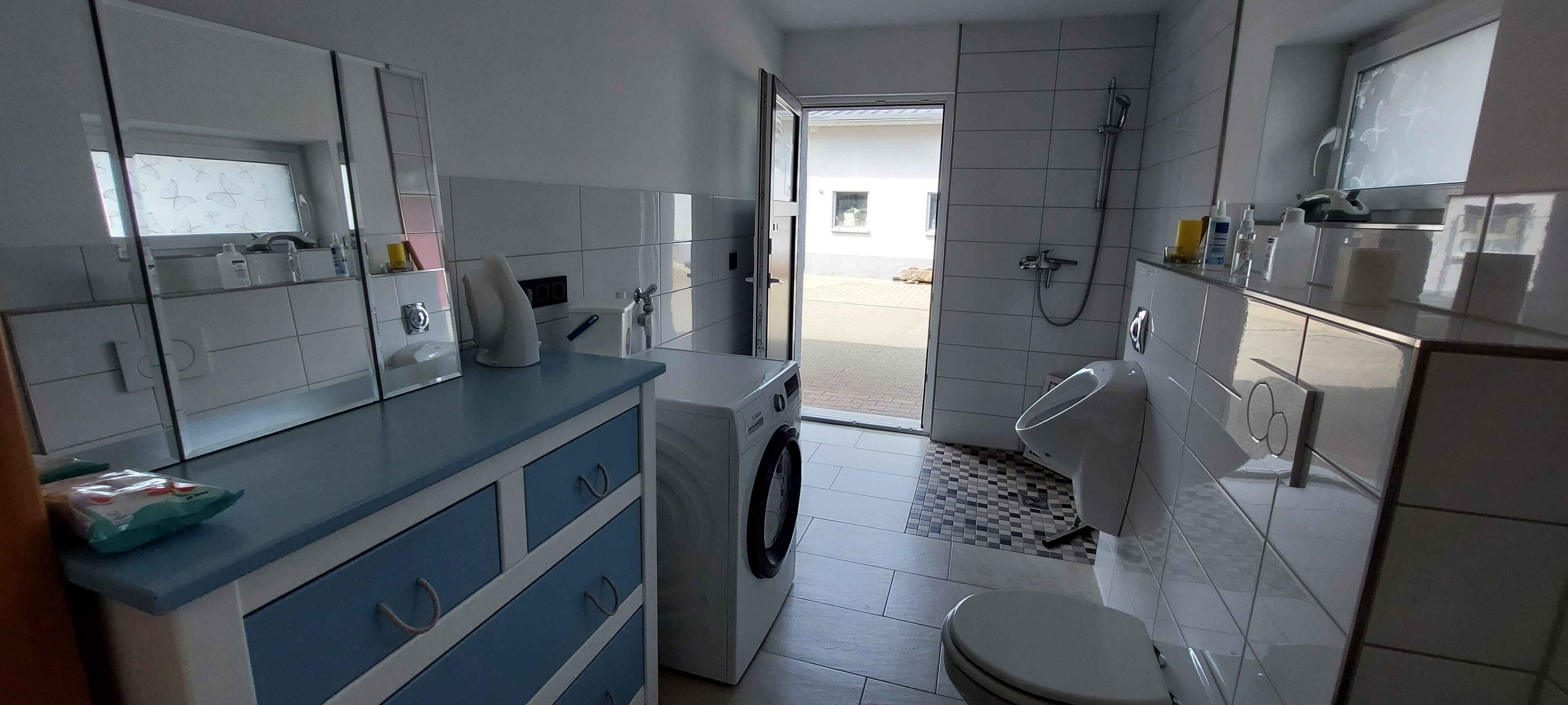Une petite cuisine équipée d’un lave-linge, de toilettes et d’un évier.