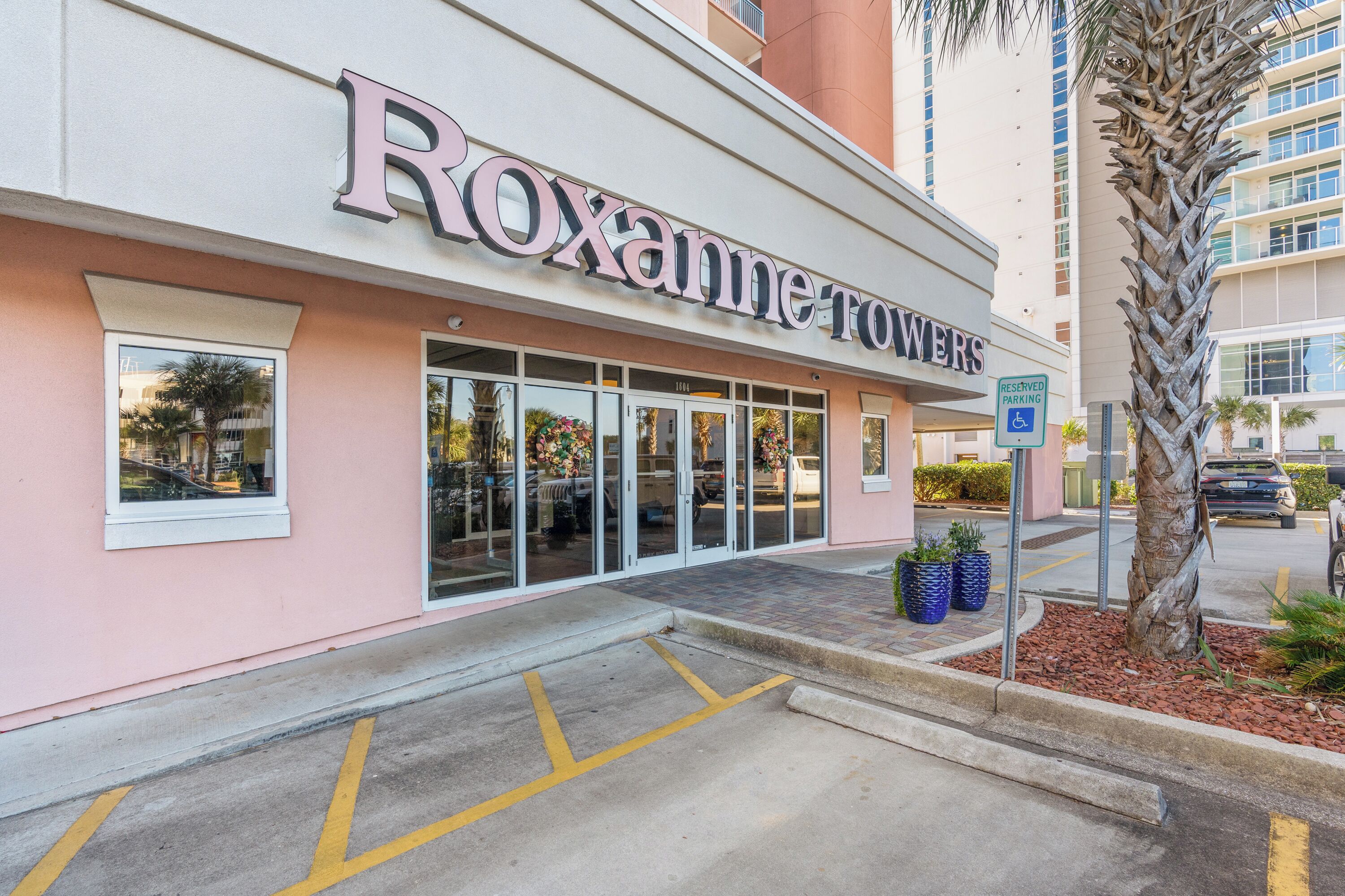 L'ingresso di un hotel con un cartello che riporta 'Roxanne Towers'.