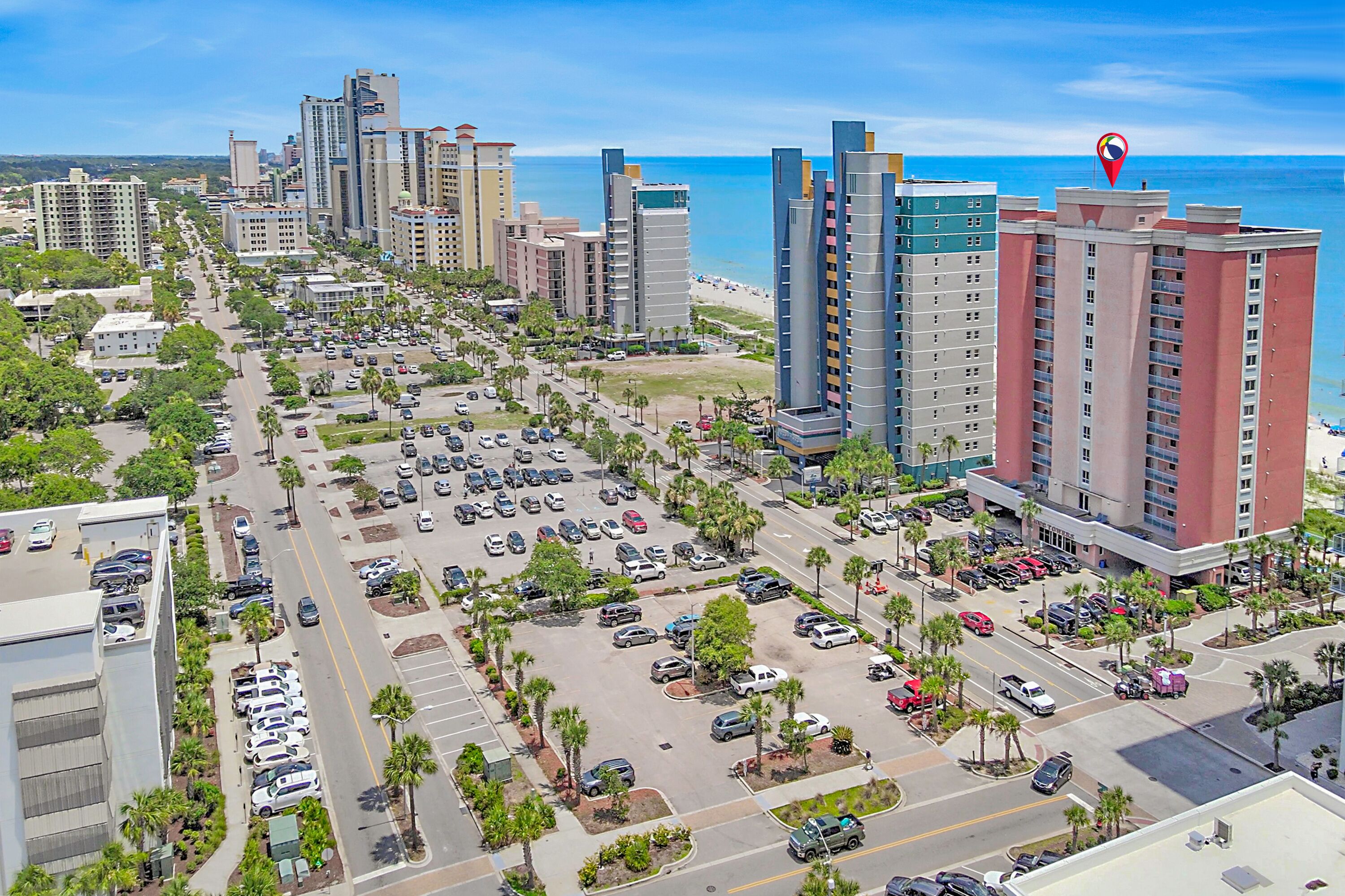 Un grand hôtel à plusieurs étages, doté d’un parking et offrant une vue sur la plage.