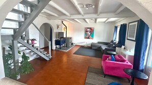 A spacious living area with a staircase, a fireplace, a sofa, and a television. - Villa with fabulous views, pool, pool table, table tennis table, 15mins to beach (Amoreira, Obidos)