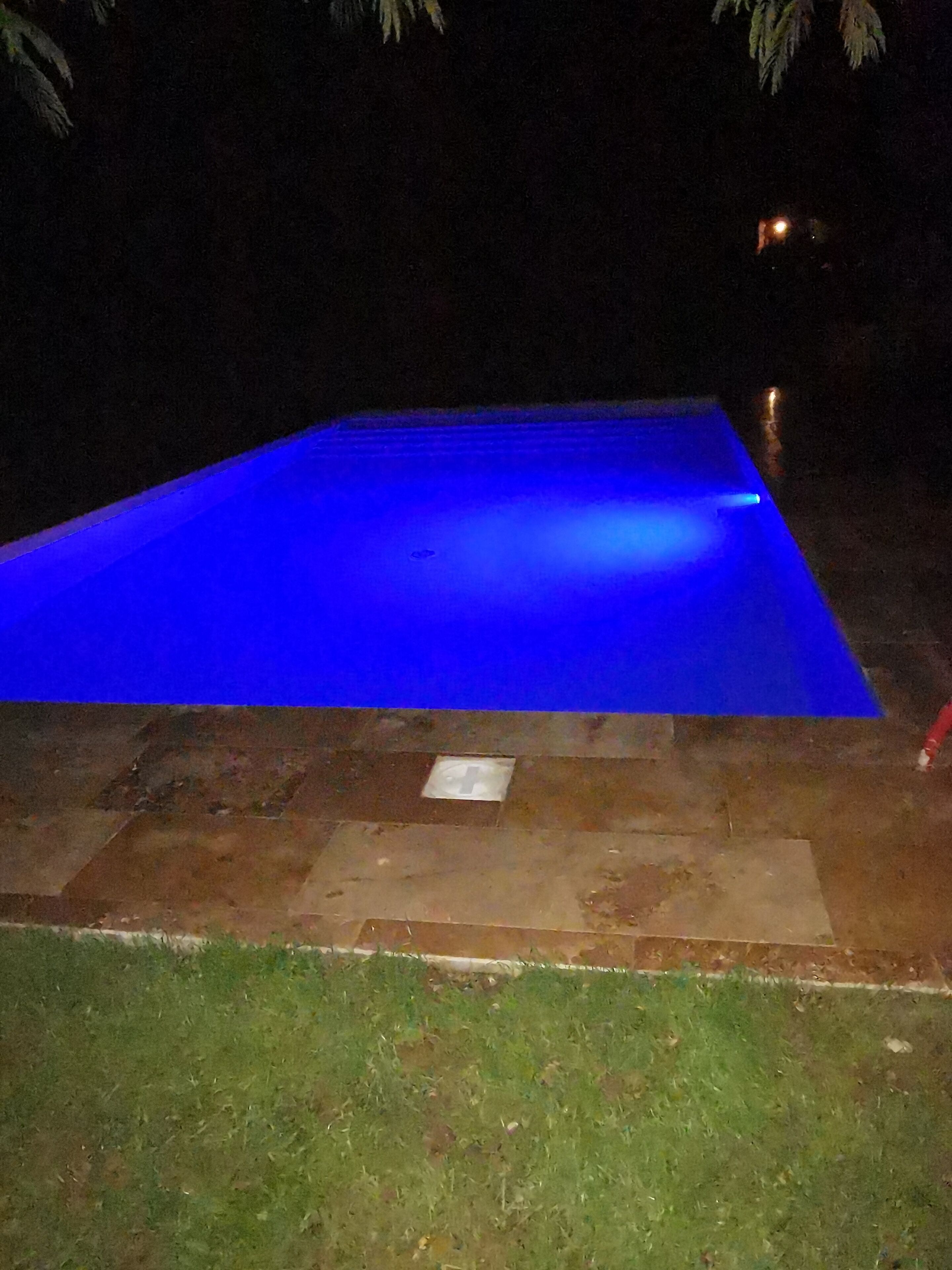 Ein Schwimmbad mit blauem Licht in der Nacht.