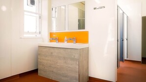Une salle de bain moderne avec un meuble-lavabo blanc, deux vasques et un grand miroir au-dessus.