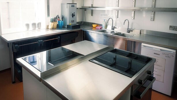 Una cocina moderna con electrodomésticos de acero inoxidable, un fregadero y un lavavajillas.