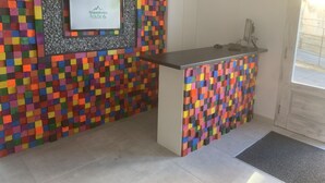 Uma cozinha com azulejos coloridos em mosaico, geladeira embutida e pia.