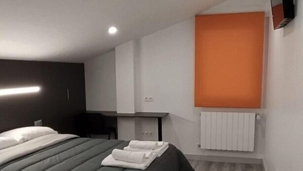 Quarto de hotel moderno com cama, escrivaninha e radiador.