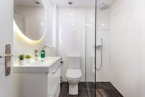 Regadera, secadora de cabello, toallas, papel de baño 