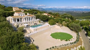 Un'ampia villa con piscina, immersa nel verde e con vista sulle montagne lontane.