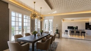 Un'area pranzo moderna con un tavolo lungo, sei sedie e un lampadario particolare.