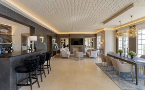 A modern living room with a bar area, a fireplace, and a large TV.