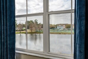Enjoy a serene view of the surrounding residential area from this room's window, overlooking a body of water.
