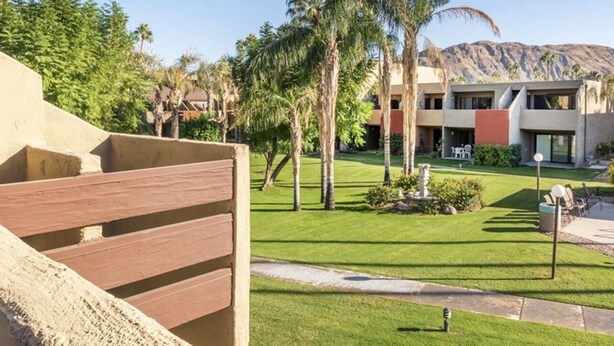 Un resort con area piscina, palme e un edificio dal design moderno.