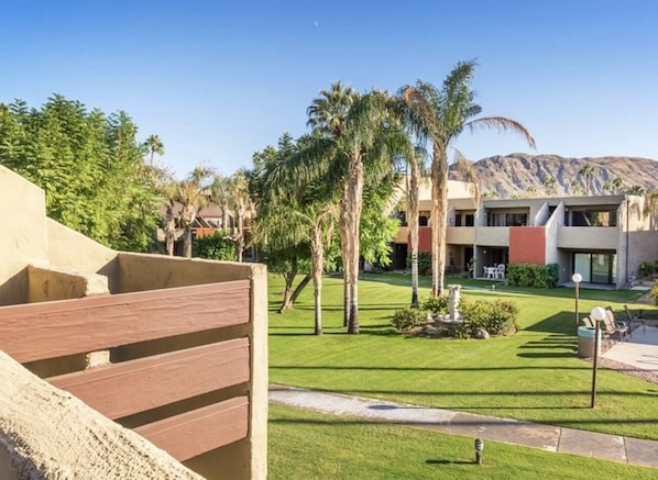 A resort with a pool area, palm trees, and a building with a modern design.
