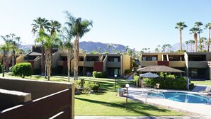 Un hotel con diversi edifici, piscina e palme.