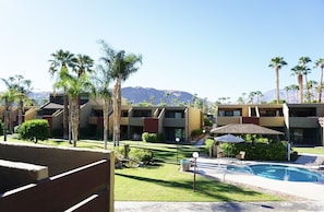 A hotel with multiple buildings, a swimming pool, and palm trees.
