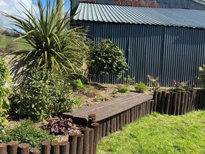Stroll through the serene garden, surrounded by lush plants and a wooden fence.