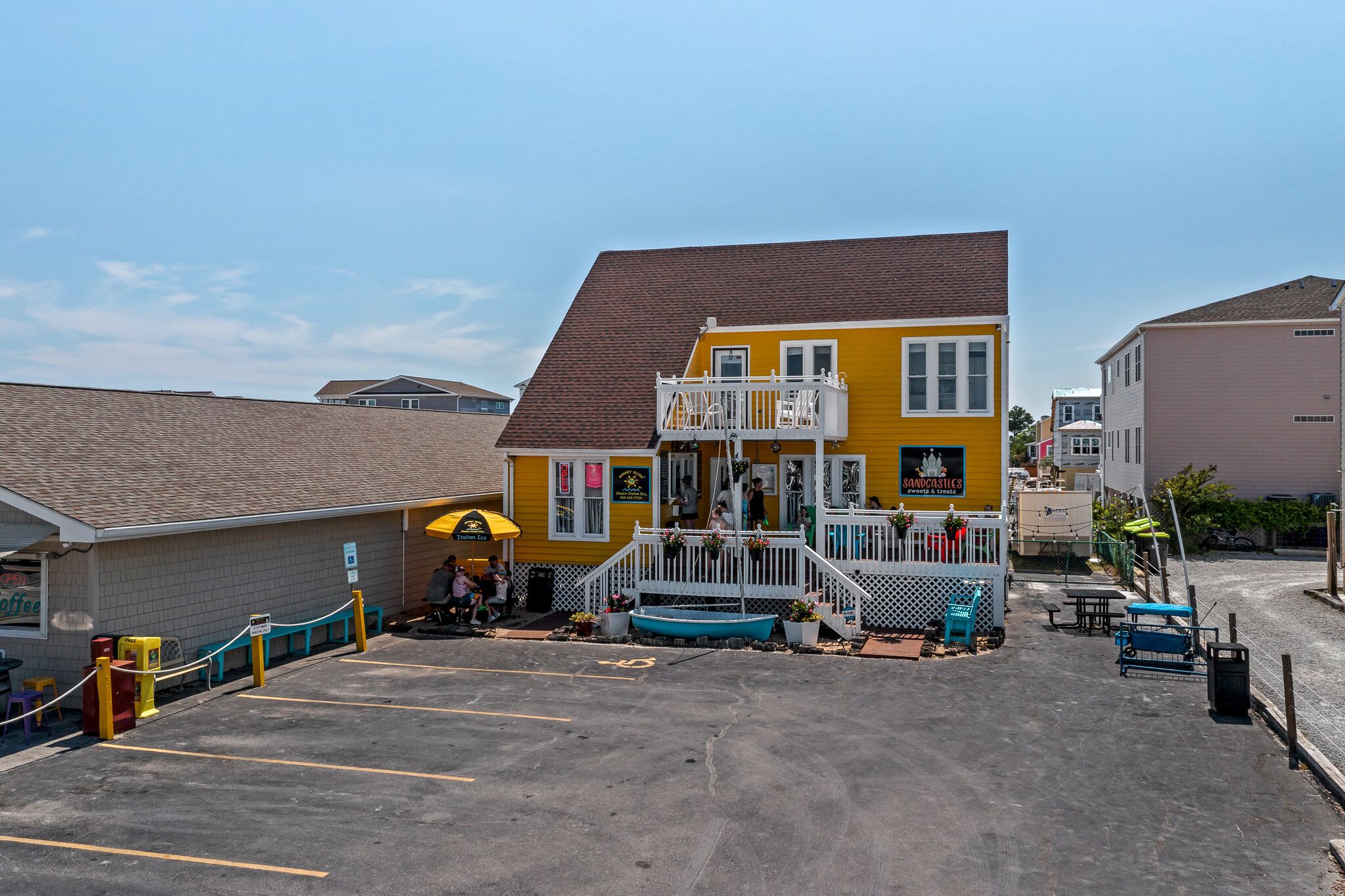 A yellow building with a balcony and a sign that reads "Sandcastle's."