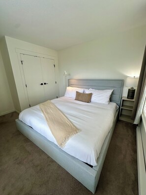 A bed with a headboard, bedside tables, and a wardrobe.