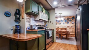 A kitchen with green cabinets, a wooden countertop, a stove, and a refrigerator. - Upgraded Rustic Themed Retreat w/screened porch in Rocky Point. (Klamath Falls)