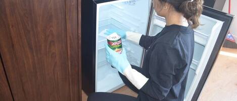 Una persona limpiando un refrigerador con una lata de peróxido de hidrógeno al 20%.