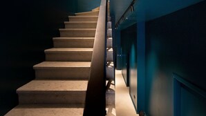 Una escalera con barandilla y un aplique en la pared.