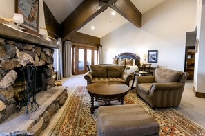 Relax in this inviting living room with a stone fireplace, comfortable seating, and plush ottoman.