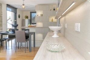 Una cocina moderna con una isla central, armarios empotrados y una lámpara colgante.