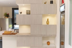 Una cocina moderna con armarios empotrados de madera, una encimera con una bandeja de aperitivos y adornos decorativos.