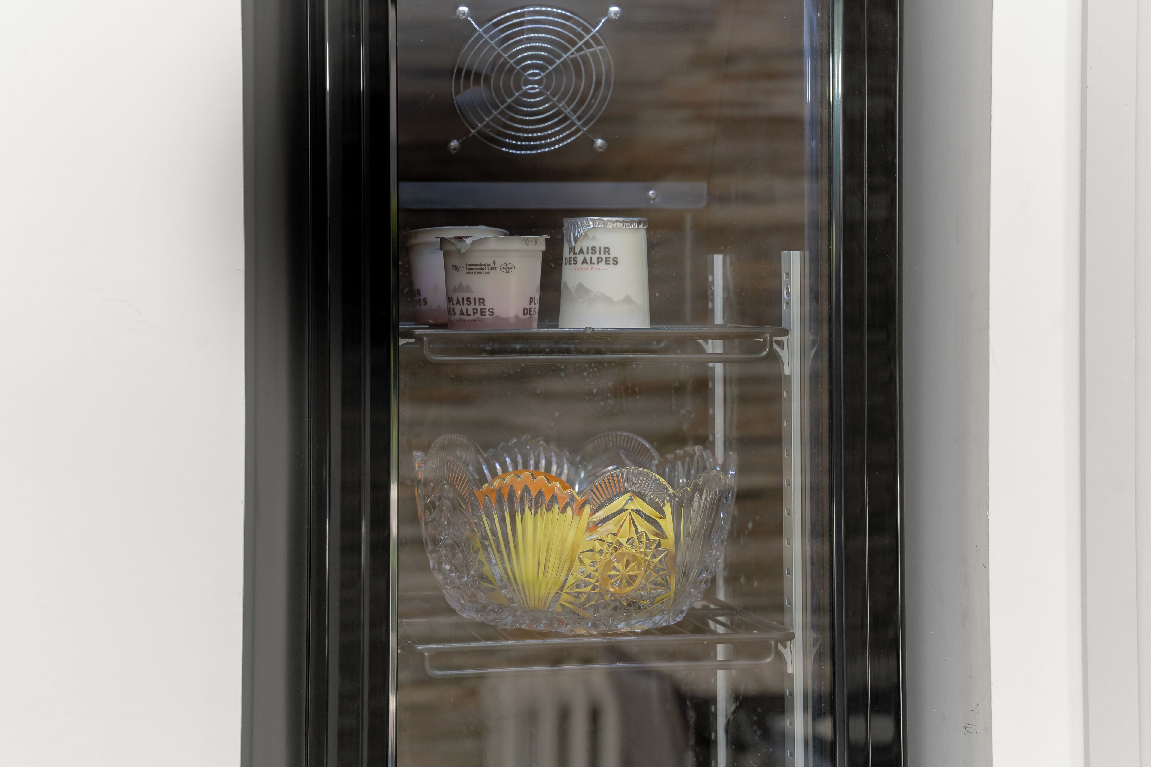 A glass-fronted display case with decorative items and labeled containers.
