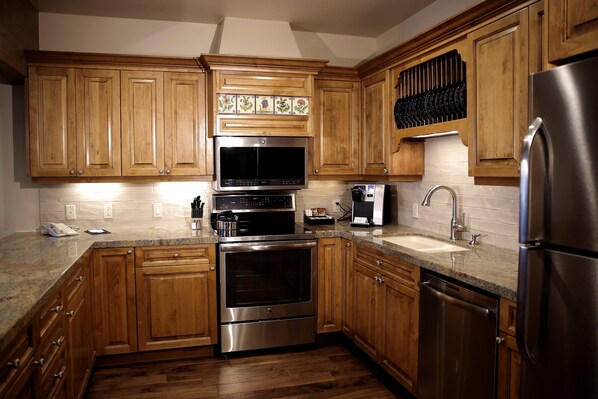 Enjoy cooking in this well-equipped kitchen with a double oven, microwave, refrigerator, sink, and coffee maker.