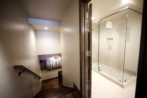 Staircase leads to a cozy seating area with a bench and shelf.