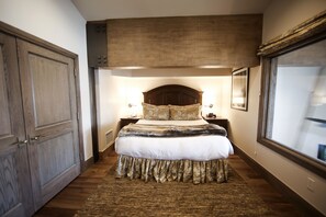 Relax in a spacious room with a large bed, decorative headboard, and matching pillow. Enjoy a view from the window.