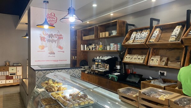 Vitrina de pastisseria amb pastissos i una màquina de cafè.