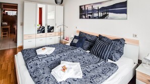 Ein Schlafzimmer mit einem großen Bett, einem Kleiderschrank, einem Nachttisch und einem Bild an der Wand.
