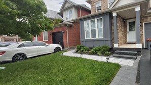 Une maison d’habitation avec un garage, une allée et une pelouse bien entretenue.