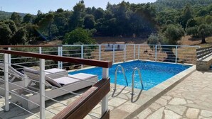 A pool area with a wooden deck, metal railings, and lounge chairs. - Perfect for peace and quiet,in the countryside (ΣΚΟΠΕΛΟΣ)