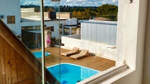 Un edificio moderno con piscina y sillas de descanso.