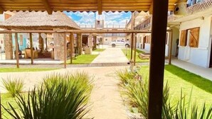 Un patio cubierto con un sendero central, rodeado de edificios con balcones y ventanas.